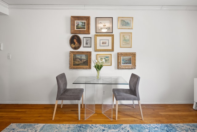 dining area with crown molding, wood finished floors, and baseboards