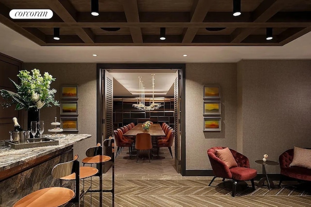 interior space with beam ceiling, a notable chandelier, coffered ceiling, and visible vents