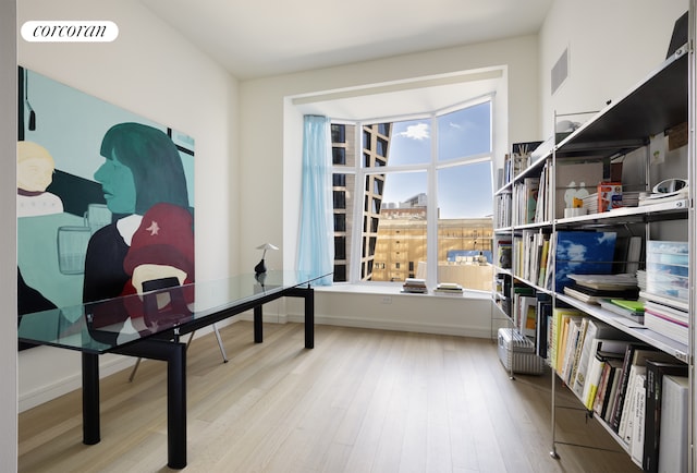 office area with visible vents, baseboards, and wood finished floors