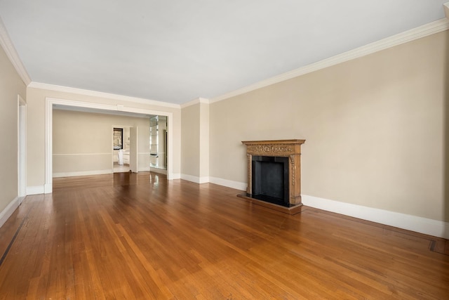 unfurnished living room featuring a fireplace with raised hearth, crown molding, baseboards, and wood finished floors