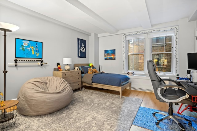 bedroom featuring beamed ceiling and wood finished floors