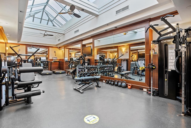 gym with visible vents, a skylight, a high ceiling, and ceiling fan