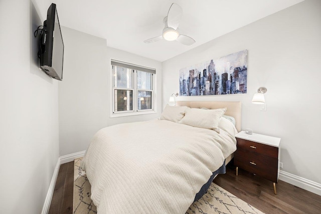 bedroom with a ceiling fan, baseboards, and wood finished floors