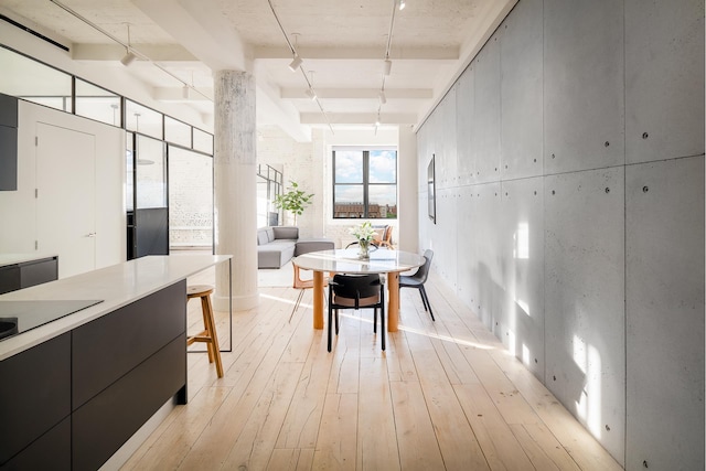 dining space featuring beamed ceiling, rail lighting, and light wood-type flooring