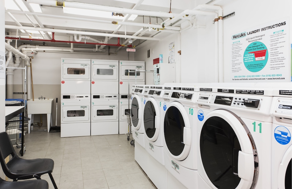 shared laundry area featuring light tile patterned flooring, stacked washing maching and dryer, and separate washer and dryer