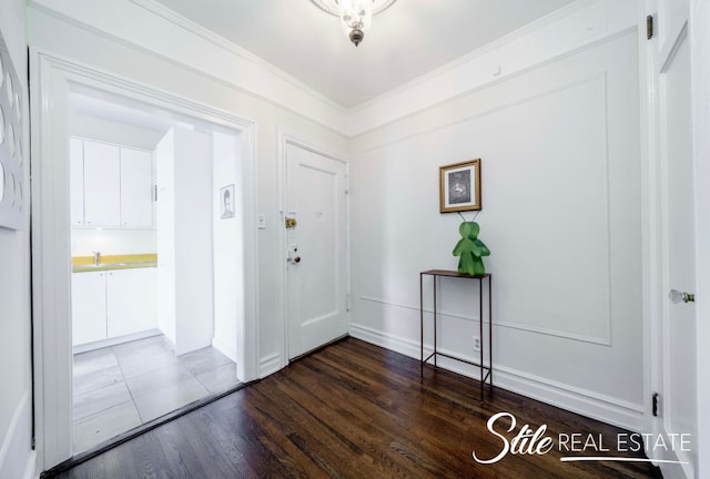 entryway featuring dark wood finished floors, baseboards, and ornamental molding