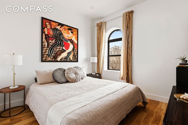 bedroom with baseboards and wood finished floors