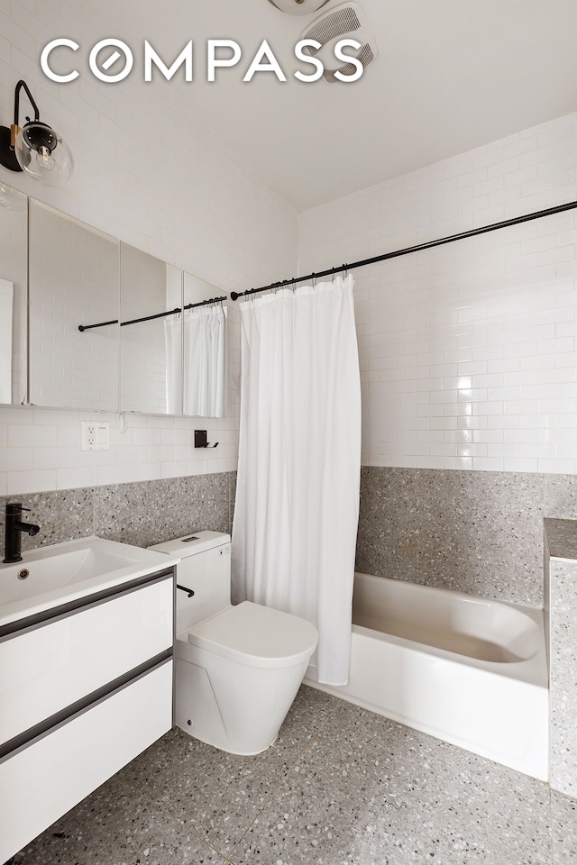 bathroom with shower / bath combo with shower curtain, toilet, tasteful backsplash, tile walls, and vanity