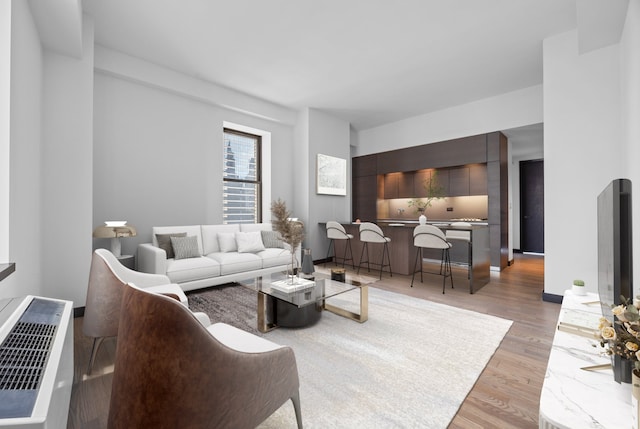 living room featuring arched walkways and light wood-type flooring