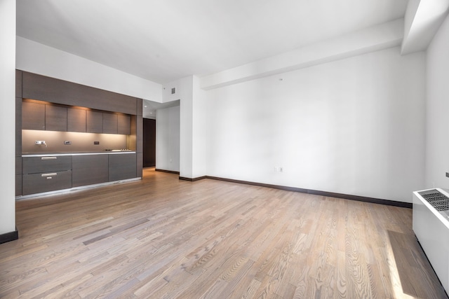 unfurnished living room with visible vents, baseboards, and light wood-style flooring