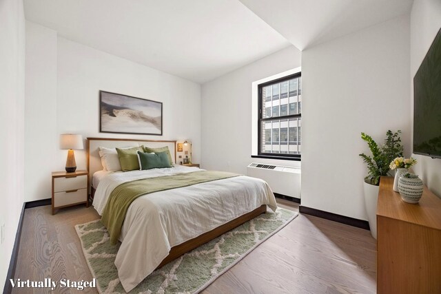 20 Pine St Unit 2907, New York City, NY 10005 - bedroom with radiator, wood finished floors, and baseboards