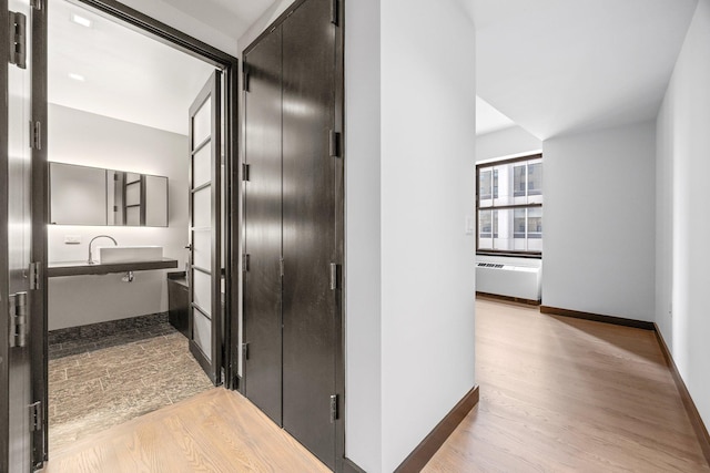 20 Pine St Unit 2907, New York City, NY 10005 - hallway with wood finished floors, radiator heating unit, and baseboards