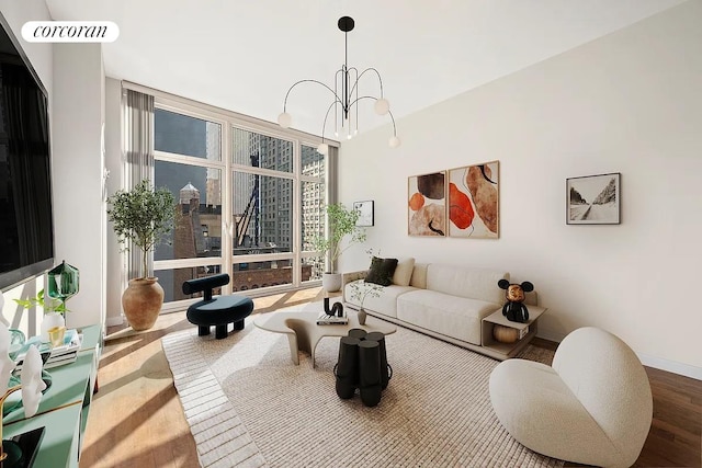 living area featuring a notable chandelier, floor to ceiling windows, baseboards, and wood finished floors