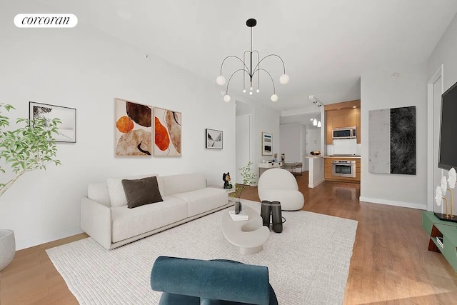 living area featuring an inviting chandelier, wood finished floors, visible vents, and baseboards