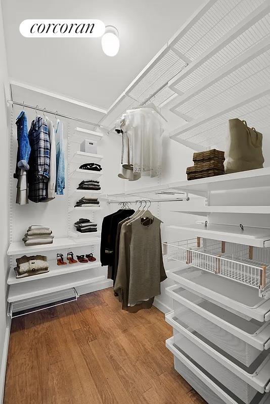 walk in closet with wood finished floors