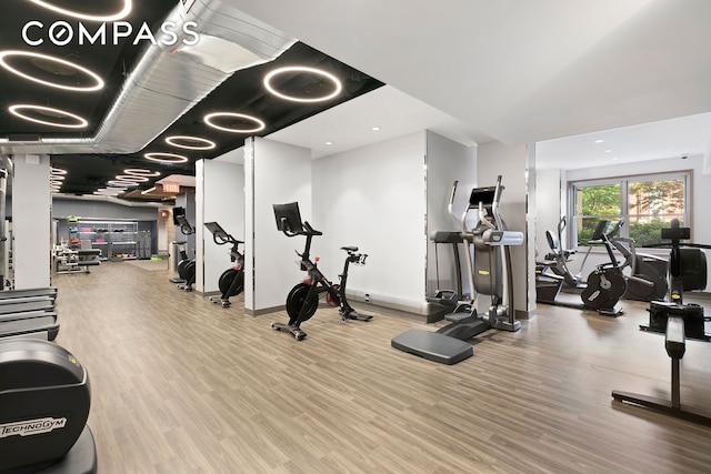 gym featuring baseboards and wood finished floors