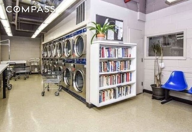 interior space featuring stacked washer / dryer, washer and dryer, and concrete block wall