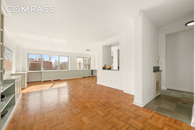 unfurnished room featuring a view of city and baseboards