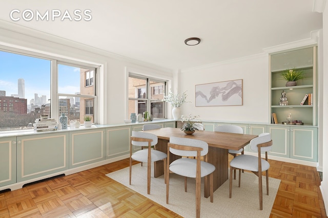 dining area with a view of city, built in shelves, and ornamental molding