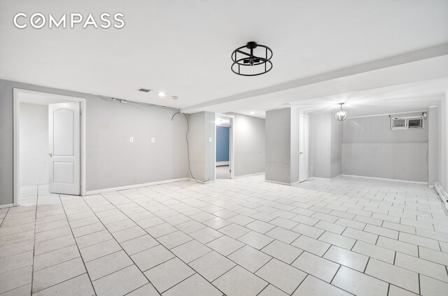 finished basement with light tile patterned floors, visible vents, and baseboards