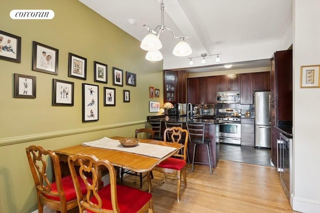 dining area featuring light wood-type flooring, visible vents, and a chandelier