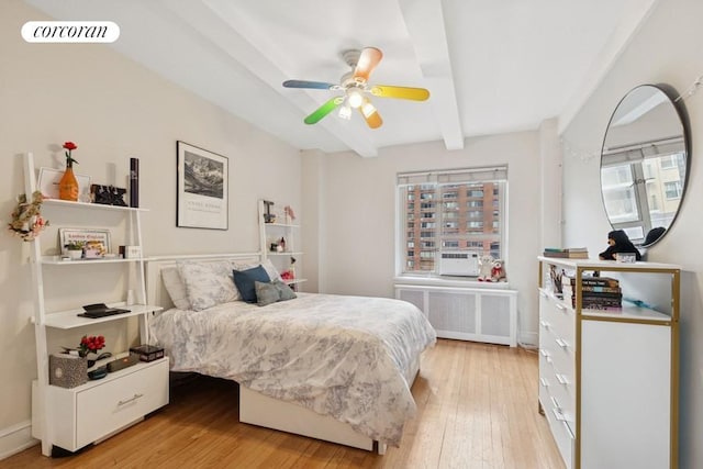 bedroom with visible vents, beamed ceiling, light wood-style floors, radiator, and ceiling fan