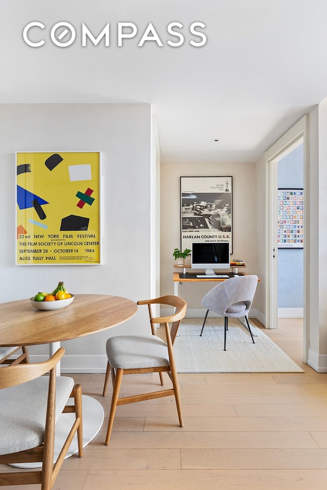 dining room featuring breakfast area, baseboards, and wood finished floors