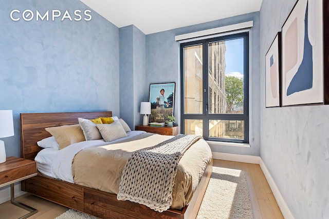 bedroom with wood finished floors and baseboards