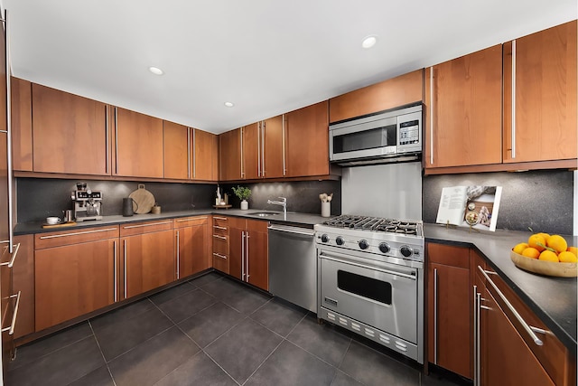 305 2nd Ave Unit 530, New York City, NY 10003 - kitchen with appliances with stainless steel finishes, a sink, backsplash, dark countertops, and dark tile patterned flooring