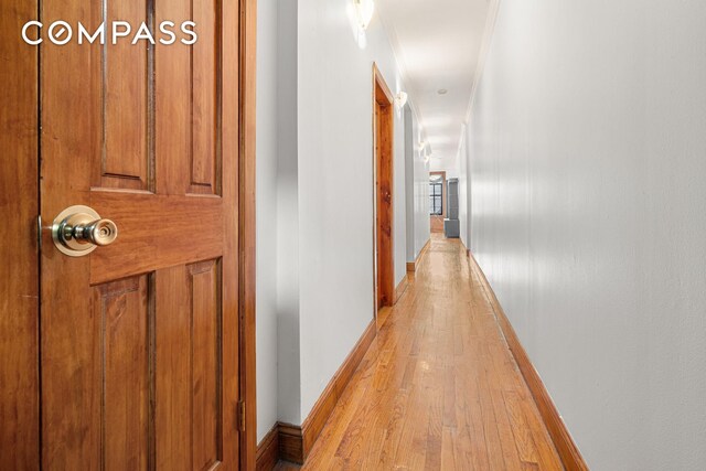 corridor with light wood finished floors and baseboards