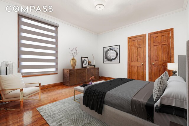 bedroom with crown molding, baseboards, and wood finished floors