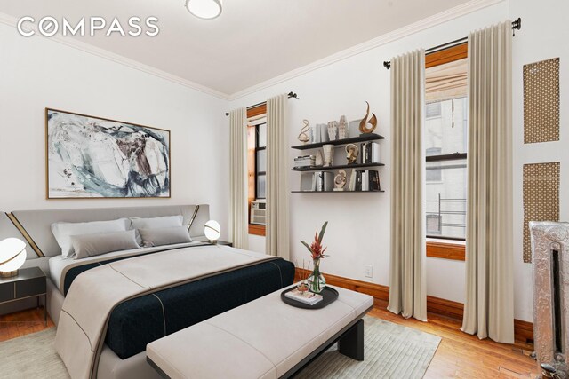 bedroom featuring baseboards, light wood finished floors, and ornamental molding