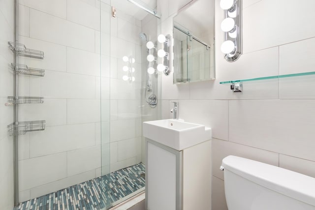 bathroom with toilet, tile walls, and a shower stall