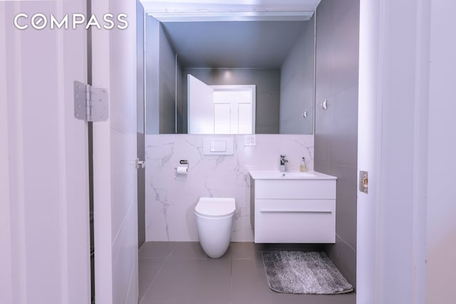 548 Lafayette Ave Unit 1A, New York City, NY 11205 - half bathroom with vanity, tile patterned flooring, toilet, and tile walls