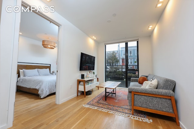 interior space with a wall of windows, baseboards, wood finished floors, and access to outside