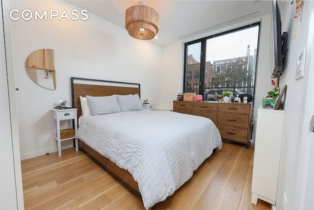 bedroom with baseboards and light wood-style flooring