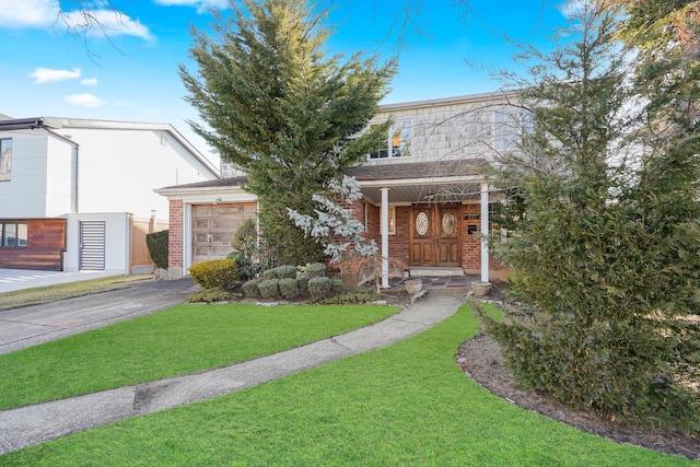 view of front facade featuring a front yard, a garage, brick siding, and driveway