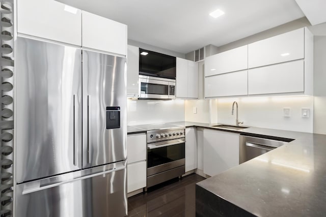 kitchen featuring visible vents, a sink, stainless steel appliances, white cabinetry, and modern cabinets