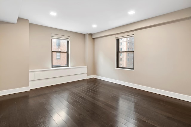 unfurnished room featuring hardwood / wood-style flooring, recessed lighting, and baseboards