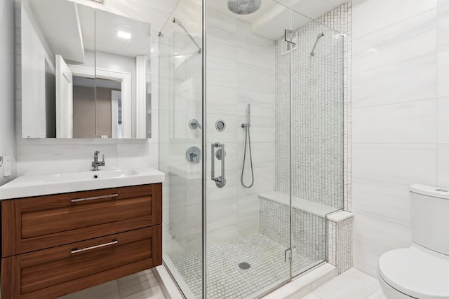 bathroom with vanity, toilet, and a shower stall