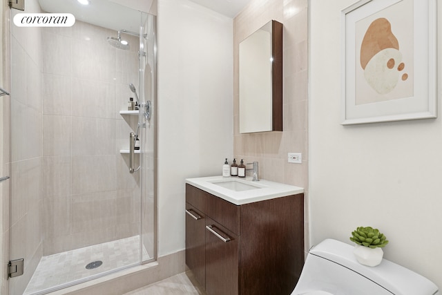 bathroom featuring vanity, a stall shower, and toilet
