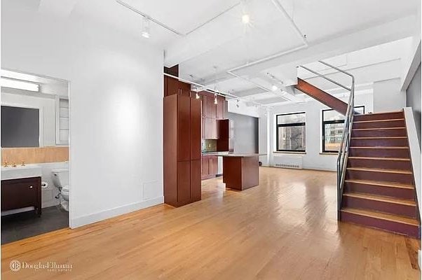 interior space featuring light wood-type flooring, stairway, baseboards, and rail lighting