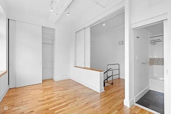 unfurnished room featuring rail lighting and light wood-type flooring