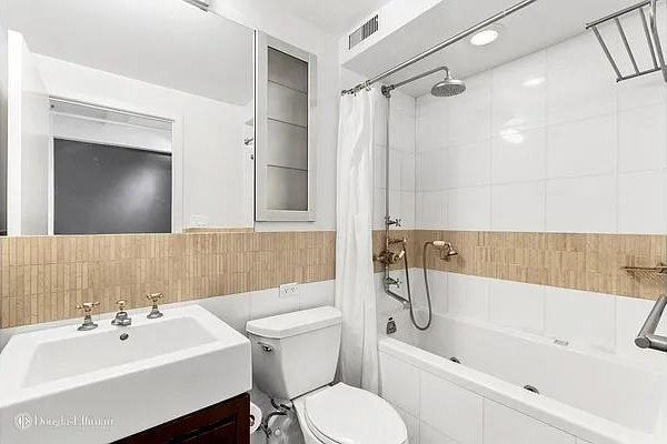 full bathroom featuring visible vents, tile walls, toilet, shower / tub combo, and vanity