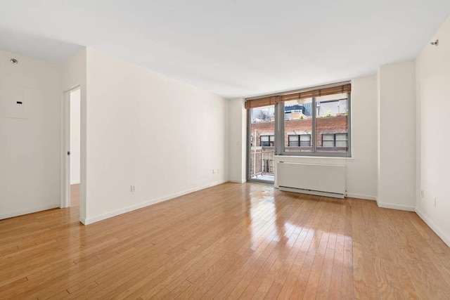 spare room featuring baseboards and light wood-style flooring