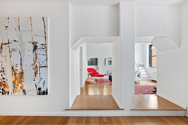 hallway featuring wood finished floors and baseboards