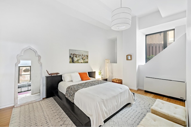 365 Bridge St Unit 2P, New York City, NY 11201 - bedroom featuring radiator, multiple windows, light wood-style floors, and baseboards