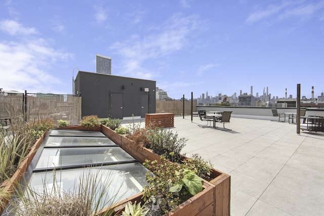 surrounding community with a view of skyline, fence, and a patio