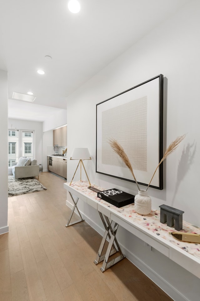 hall with light wood-style floors and recessed lighting