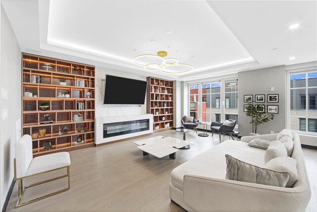 37-26 32nd St Unit 2-L, New York City, NY 11101 - living area featuring a tray ceiling, wood finished floors, recessed lighting, and a glass covered fireplace